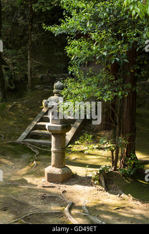 Un unico grigio pietra pagoda davanti a una breve scalinata in pietra in un tradizionale giardino giapponese Foto Stock