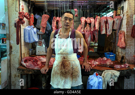 Cina, Hong Kong, 11 ottobre 2014. Un macellaio sorge di fronte al suo negozio di macellaio in Hong Kong. Foto Stock
