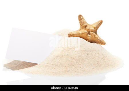 Carta bianca carta da visita con starfish sulla pila di spiaggia di sabbia, isolato su sfondo bianco Foto Stock