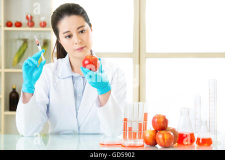 La scienza ricercatore tenendo su un impianto di OGM in laboratorio Foto Stock