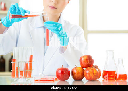 Asian donna scienziato verifica la modificazione genetica cibo sarà ok per uomo Foto Stock