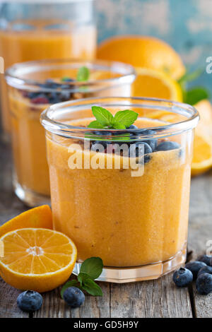 Arancione e mango smoothie con granola Foto Stock