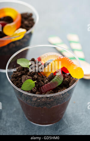 Bambini dessert al cioccolato in un bicchiere sporco e worm Foto Stock