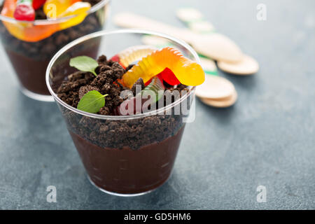 Bambini dessert al cioccolato in un bicchiere sporco e worm Foto Stock