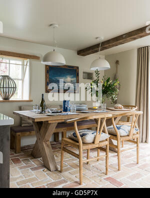 Rovere antico sedie da pranzo intorno a tavola in legno rustico in cucina con pavimenti in cotto e soffitto in legno trave Foto Stock