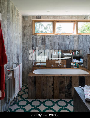 Vasca da bagno rivestita in parquet riciclato in bagno con Parquet Vinilico turchese piastrelle per pavimento da Neisha Crosland Foto Stock