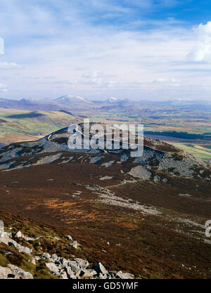 Vista da est il vertice di Yr Eifl oltre tre'r Ceiri Iron Age hillfort verso le montagne innevate di Snowdonia, Lleyn, Galles del Nord, Regno Unito Foto Stock