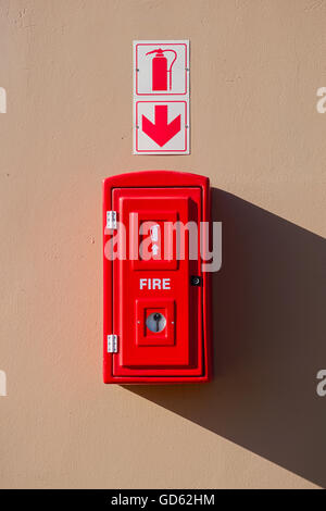 Red fire estintore cassetta pensile sulla parete Foto Stock