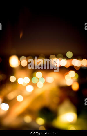 Spider retroilluminati da un colorato illuminano e bokeh di luci della città che risplende nelle tenebre visto come una silhouette Foto Stock