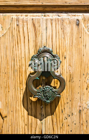 Ferro battuto respingente artigianalità di antico edificio storico nella porta di legno Foto Stock