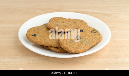 Vista laterale della fetta di mirtillo i cookie su una piastra bianca in cima a una tavola di legno alto. Foto Stock