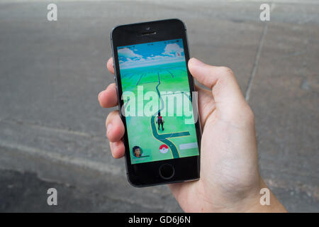 Bangkok, Tailandia - 11 Luglio 2016 : Apple iPhone5s tenuto in una mano che mostra il suo schermo con Pokemon Go. Foto Stock