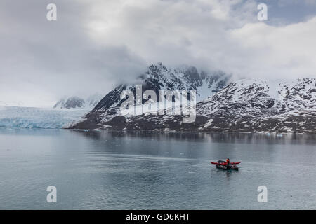 Lone zattera gonfiabile in Liefdefjorden, arcipelago delle Svalbard, Norvegia. Monacobreen (Monaco glacier) è visibile dietro. Foto Stock