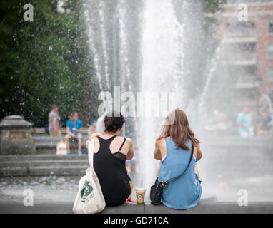 I Newyorkesi e visitatori godere il microclima creato dalla fontana di Washington Square Park nel Greenwich Village di New York giovedì 7 luglio 2016. Le temperature sono dovrebbe essere in alta 90's F per la seconda giornata di oggi e di domani. Tre 90 grado o al di sopra di giorni in una fila è ufficialmente un ondata di calore. ( © Richard B. Levine) Foto Stock