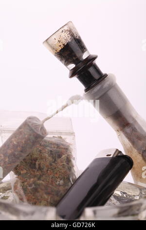 Close up di marijuana giunto fatto con traslucido rolling papers, plastica larghi di marijuana essiccate, nero più leggero e il tubo su sfondo bianco Foto Stock