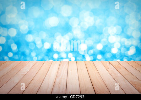 Piattaforma di legno con il colore blu glitter sfondo sfocato. Foto Stock