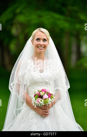 Sposa abiti da sposa con bouquet nuziale e velo, Germania Foto Stock