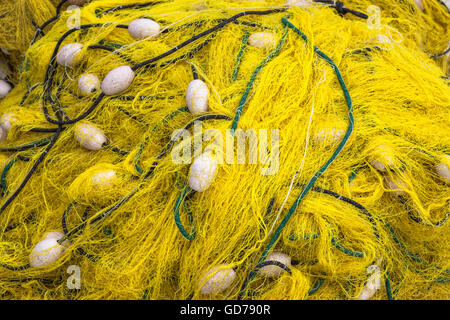 Reti da pesca gialle accatastate sulla banchina, Perast, Montenegro Foto Stock