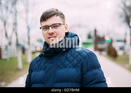 Giovane uomo bello in giacca blu all'aperto in stagione primavera Foto Stock