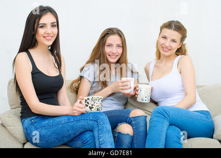 Tre amici felice di parlare e di bere il caffè o tè Foto Stock