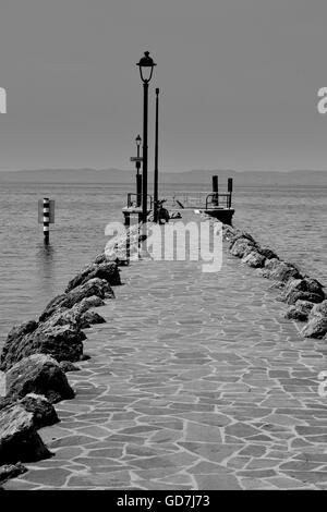 Rock e pavimentata in Dock Bardolino Verona, Lago di Garda). Effetto monocromatici in bianco e nero Foto Stock