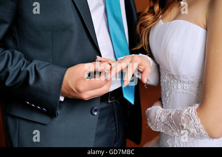 Lo sposo abiti sposa matrimonio anello al dito Foto Stock