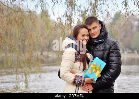 L uomo dà una donna un dono all'aperto Foto Stock