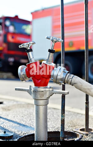 Il tubo flessibile di acqua collegata all'idrante antincendio durante il funzionamento Foto Stock