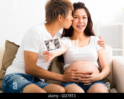 Felice di gravidanza e il marito che mostra immagine ad ultrasuoni Foto Stock