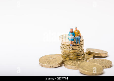Concetto di immagine di due pensionati seduto su una pila di libbra di monete Foto Stock