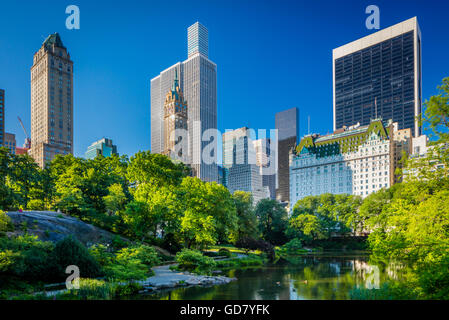 Il Laghetto di Central Park di New York City, con edifici di midtown visibile in distanza Foto Stock