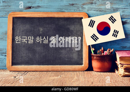 Una lavagna con la questione non si parla coreano? Scritto in coreano, una pentola con matite, alcuni libri e la bandiera del Sud Kore Foto Stock