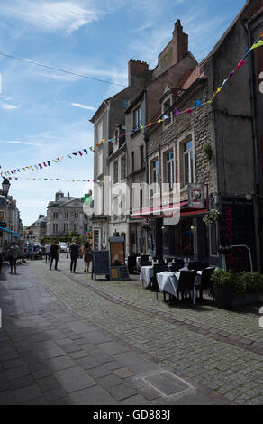 Lazy francese vista guardando verso il basso la Rue de Lille immerso nella luce del pomeriggio. Bunting e cene alfresco. Boulogne-sur-Mer, Francia. Foto Stock