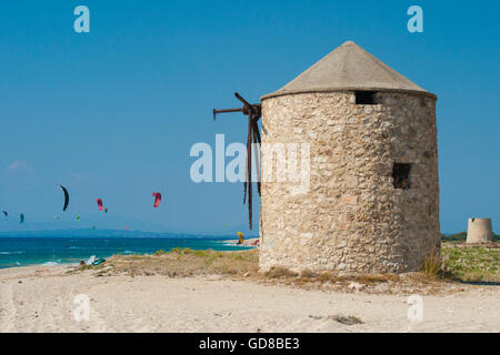 Vecchi Mulini a vento su una spiaggia popolata da surfisti e kitesurfisti in Lefkada, Lefkas Foto Stock