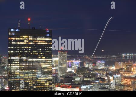 Una lunga esposizione del centro cittadino di Boston al tramonto con gli aerei che decollano dall'Aeroporto Logan di fronte al porto di Boston. Foto Stock