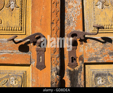 Vecchio rustico porta con metallo arrugginito maniglie della porta. Foto Stock