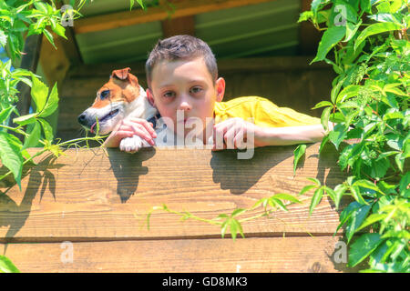 Ragazzo sorridente con il cane su treehouse. L'estate! Foto Stock