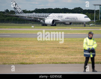 Farnborough Hampshire, Regno Unito. Il 14 luglio 2016. Il giorno 4 del Farnborough International Airshow di commercio. Airbus battenti demo, la A350 XVB aereo di linea sulla pista di rullaggio dopo i suoi battenti demo, con pista guardia di sicurezza in primo piano. Credito: aviationimages/Alamy Live News. Foto Stock