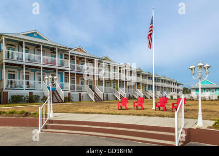 Sedie rosse di fronte a una fila di waterfront case condominio su East Beach Boulevard in Pass Christian, Mississippi Foto Stock