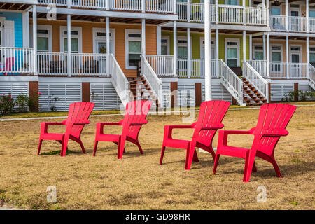 Sedie rosse di fronte a una fila di waterfront case condominio su East Beach Boulevard in Pass Christian, Mississippi Foto Stock