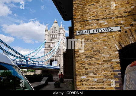 Shad Thames è una storica riverside street vicino al Tower Bridge in direzione Bermondsey, Londra, Inghilterra il Tower Bridge in background Foto Stock