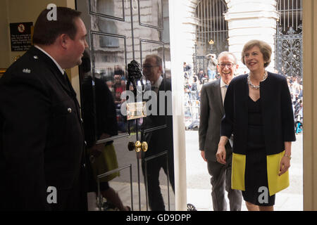 Nota raccolto alternativo il nuovo primo ministro, Theresa Maggio, seguita da suo marito Filippo Giovanni, arriva a 10 Downing Street, Londra, dopo un incontro con la regina Elisabetta II e di accettare il suo invito a diventare Primo Ministro e formare un nuovo governo. Foto Stock