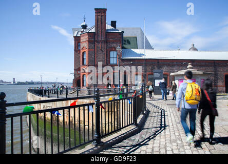 Le persone che si godono la passeggiata costiera lungo il fiume sul lungomare di Liverpool, Merseyside, Regno Unito. Il Pier Head è una delle principali attrazioni turistiche centrali, con diversi importanti monumenti e sviluppi moderni che concentrano l'attenzione sulla storia e il patrimonio della città come porto principale sul Mersey. Foto Stock