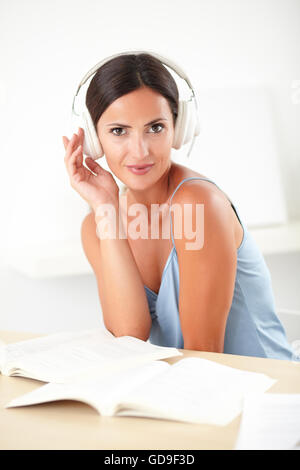 Donna elegante in blu camicetta seduti e ascoltare la musica a casa Foto Stock