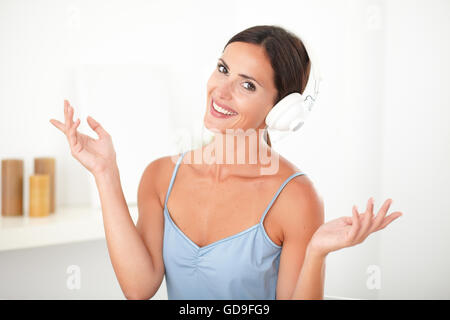 Smart donna latina con cuffie cercando rilassati ascoltando la musica indoor Foto Stock