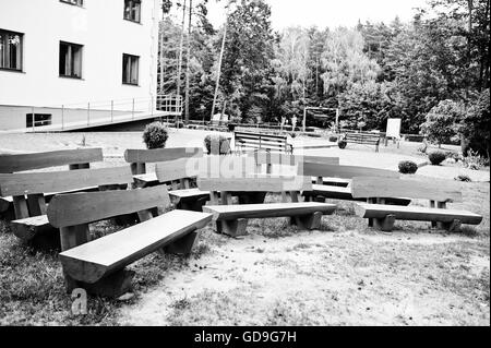 Fila di panche di legno all'esterno. Foto in bianco e nero Foto Stock