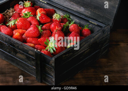 Fresche e mature di fragole succo di frutta in scatola di legno su legno scuro dello sfondo. Foto Stock