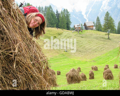 L'Italia, Trentino Alto Adige, Dolomiti Sextener, multi-giorno escursione, donna di nascondersi dietro le balle di paglia, sul Rotwandwiese Foto Stock