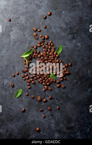 I chicchi di caffè e foglie di menta sulla pietra scura tabella. Vista superiore Foto Stock