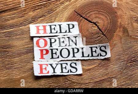 Acronimo di speranza - Contribuire ad aprire gli occhi dei popoli , le parole sulla carta tagliata su uno sfondo di legno Foto Stock